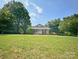 Charming home with a light-colored facade, complemented by lush greenery, set under a partly cloudy sky at 329 Highland Dr, Lincolnton, NC 28092