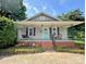 Welcoming front porch with light gray siding, a swing, and a vibrant teal front door adorned with a 'Welcome' sign at 329 Highland Dr, Lincolnton, NC 28092
