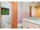 Tidy bathroom with white toilet and sink, complemented by pink tiles and wallpaper at 3526 Craig Ave, Charlotte, NC 28211