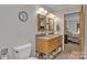Inviting bathroom featuring a double vanity, a clock, and a toilet at 3998 Holly Springs Dr # 20, Newton, NC 28658