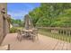 A deck with a table, chairs, and umbrella, offering an outdoor living space with green scenery at 3998 Holly Springs Dr # 20, Newton, NC 28658