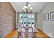 Inviting dining room with brick accent wall, wood floors, and chandelier lighting at 3998 Holly Springs Dr # 20, Newton, NC 28658