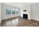 Cozy living room with a fireplace, large windows, and wood-look flooring perfect for modern living at 4026 Honey Locust Dr, Charlotte, NC 28215