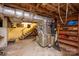This unfinished basement features wooden stairs, exposed beams, and ductwork at 411 Hanna St, Gastonia, NC 28052