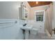 Traditional bathroom with a pedestal sink, black and white tiled floor, and beadboard paneling at 411 Hanna St, Gastonia, NC 28052
