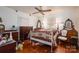 This bedroom features hardwood floors, a ceiling fan, and a large white-frame bed at 411 Hanna St, Gastonia, NC 28052