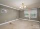 This empty bedroom features neutral walls, white trim, a large window, and carpet floors at 411 Hanna St, Gastonia, NC 28052