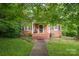 Charming brick home with a cozy front porch and well-maintained lawn at 411 Hanna St, Gastonia, NC 28052