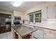 Kitchen with white cabinetry, stainless-steel island, and open access to a dining area, perfect for entertaining at 411 Hanna St, Gastonia, NC 28052