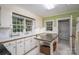 Charming kitchen with white cabinets, stainless steel island, and plenty of natural light from large windows at 411 Hanna St, Gastonia, NC 28052