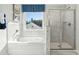 Bright bathroom featuring tub with shower and large window providing exterior views at 423 Balboa St, Matthews, NC 28104