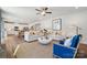 Open-concept living room with white sofas, blue armchairs, and natural-light filled kitchen at 423 Balboa St, Matthews, NC 28104