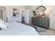 Well-lit bedroom with a large dresser, decorative mirror, and a glimpse into an adjacent room at 4400 Dusty Orchard Rd, Kannapolis, NC 28081
