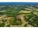 Expansive aerial view of the property surrounded by lush green trees and open fields at 5258 E Bandys Cross Rd, Catawba, NC 28609