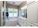 Bright bathroom with a soaking tub, double sink vanity, white cabinets, and a large window bringing in natural light at 5258 E Bandys Cross Rd, Catawba, NC 28609