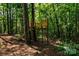 View of a wooden backyard treehouse with a small slide in a lush wooded area at 5258 E Bandys Cross Rd, Catawba, NC 28609