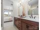 Bright bathroom with dual sinks, modern fixtures, and an en-suite door to the adjacent bedroom at 5508 Swaling St, Charlotte, NC 28217