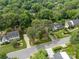 Aerial view of a home nestled among mature trees with a well-maintained lawn and landscaping at 5517 Alexa Rd, Charlotte, NC 28277