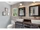 Modern bathroom features a painted brick wall, dual vessel sinks, and industrial-style lighting at 5517 Alexa Rd, Charlotte, NC 28277