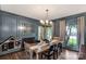 Elegant dining room with decorative paneling, stylish light fixture, and rustic wooden table at 5517 Alexa Rd, Charlotte, NC 28277