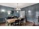 Elegant dining room with grey walls, hardwood floors, modern lighting, and a dining table set for a meal at 5517 Alexa Rd, Charlotte, NC 28277