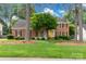 Charming brick home with black shutters, yellow front door, manicured lawn, and mature trees, creating a welcoming curb appeal at 5517 Alexa Rd, Charlotte, NC 28277