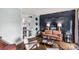 Stylish living room with hardwood floors, dark accent wall, modern furniture, and glass doors to another room at 5517 Alexa Rd, Charlotte, NC 28277
