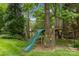 Backyard with a fun treehouse featuring a slide and rock climbing wall in a fenced-in yard at 5517 Alexa Rd, Charlotte, NC 28277