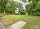 Large backyard with plenty of greenery, enclosed by a wooden fence, and featuring a storage shed at 5629 Ruth Dr, Charlotte, NC 28215