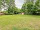 Expansive backyard featuring a storage shed, mature trees, and privacy fence at 5629 Ruth Dr, Charlotte, NC 28215