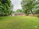 Expansive backyard with lush green grass, surrounded by mature trees, offering privacy and space at 5629 Ruth Dr, Charlotte, NC 28215