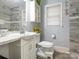 Bathroom features updated gray tile, modern fixtures, and a window for natural light at 5629 Ruth Dr, Charlotte, NC 28215