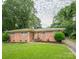 A single-story brick home with a well-maintained lawn and mature landscaping at 5629 Ruth Dr, Charlotte, NC 28215