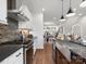 Modern kitchen featuring stainless steel appliances, white cabinetry, and stylish brick backsplash at 5731 Castlerea Dr, Charlotte, NC 28217