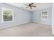 Primary bedroom featuring neutral walls, carpet, and two large windows at 613 Church St, Belmont, NC 28012
