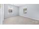 Bright bedroom with two large windows and neutral colored walls and carpet at 613 Church St, Belmont, NC 28012