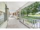 Expansive front porch offers views of a picturesque green space with mature trees and a peaceful walking path at 613 Church St, Belmont, NC 28012