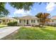 Adorable single-story home exhibits a delightful front porch, lush landscaping, and a well-maintained lawn at 613 Church St, Belmont, NC 28012
