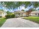 Quaint single-story house boasts a cozy front porch, meticulous landscaping, and an expansive concrete driveway at 613 Church St, Belmont, NC 28012