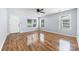 Bright living room featuring wood-look floors, neutral walls, ceiling fan, and natural light from double-hung windows at 613 Church St, Belmont, NC 28012