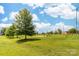 Park featuring a grassy field with mature trees, basketball court and playground at 613 Church St, Belmont, NC 28012