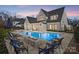 Stunning backyard with a swimming pool, spa, outdoor kitchen, fire pit, and beautiful home exterior at 7215 Alexander Rd # 4, Charlotte, NC 28270