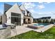 Beautiful backyard with an outdoor kitchen, pool, spa and view of the house's exterior at 7215 Alexander Rd # 4, Charlotte, NC 28270