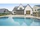 Backyard with a luxurious pool, stone patio, and a beautifully designed white brick house at 7215 Alexander Rd # 4, Charlotte, NC 28270