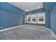 Spacious bedroom featuring light gray carpet, white trim, and natural light from three windows at 7215 Alexander Rd # 4, Charlotte, NC 28270