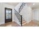 Bright foyer featuring a modern staircase with a black railing and wood steps and wood floors at 7215 Alexander Rd # 4, Charlotte, NC 28270