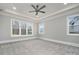 Spacious main bedroom with neutral colors, carpet flooring, large windows, and a ceiling fan at 7215 Alexander Rd # 4, Charlotte, NC 28270