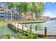 Waterfront views featuring a wooden boardwalk, lush greenery, and neighboring properties at 753 Southwest Dr, Davidson, NC 28036