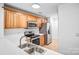 Well-lit kitchen with wood cabinets, stainless steel appliances, and a practical double-bowl sink at 753 Southwest Dr, Davidson, NC 28036
