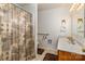 Well-lit bathroom features a shower with patterned curtain and neutral-toned vanity at 765 York Institute Rd, Hiddenite, NC 28636